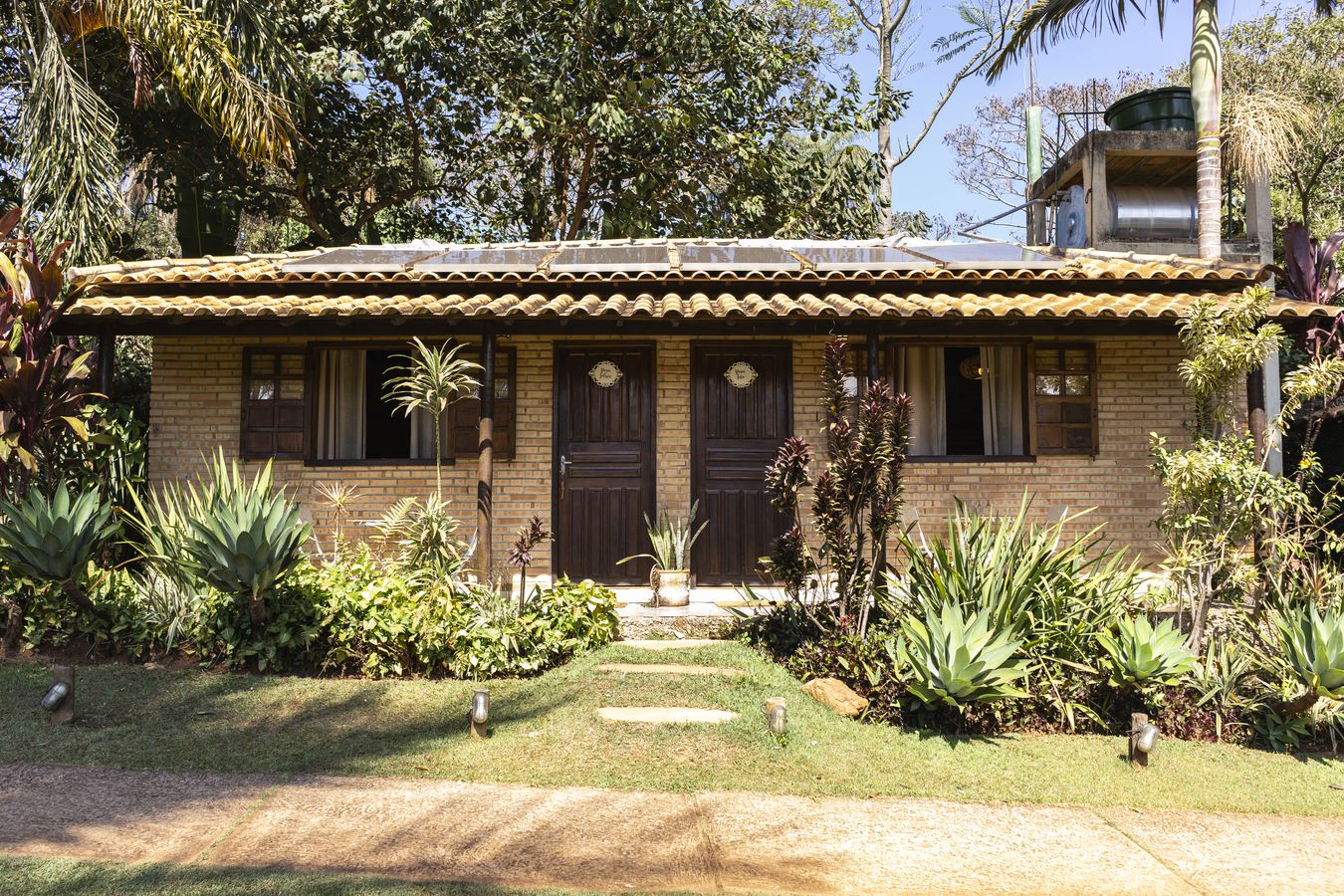 A fachada dos Chalés das Vovós, com as duas portas de madeira e o jardim de agaves na frente