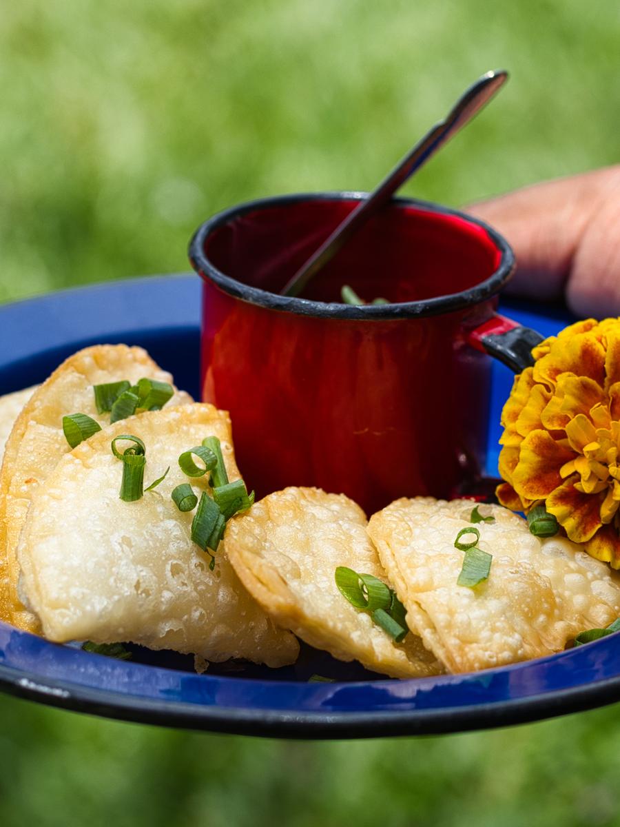 Os pastéis no prato azul, com a caneca vermelha na mão