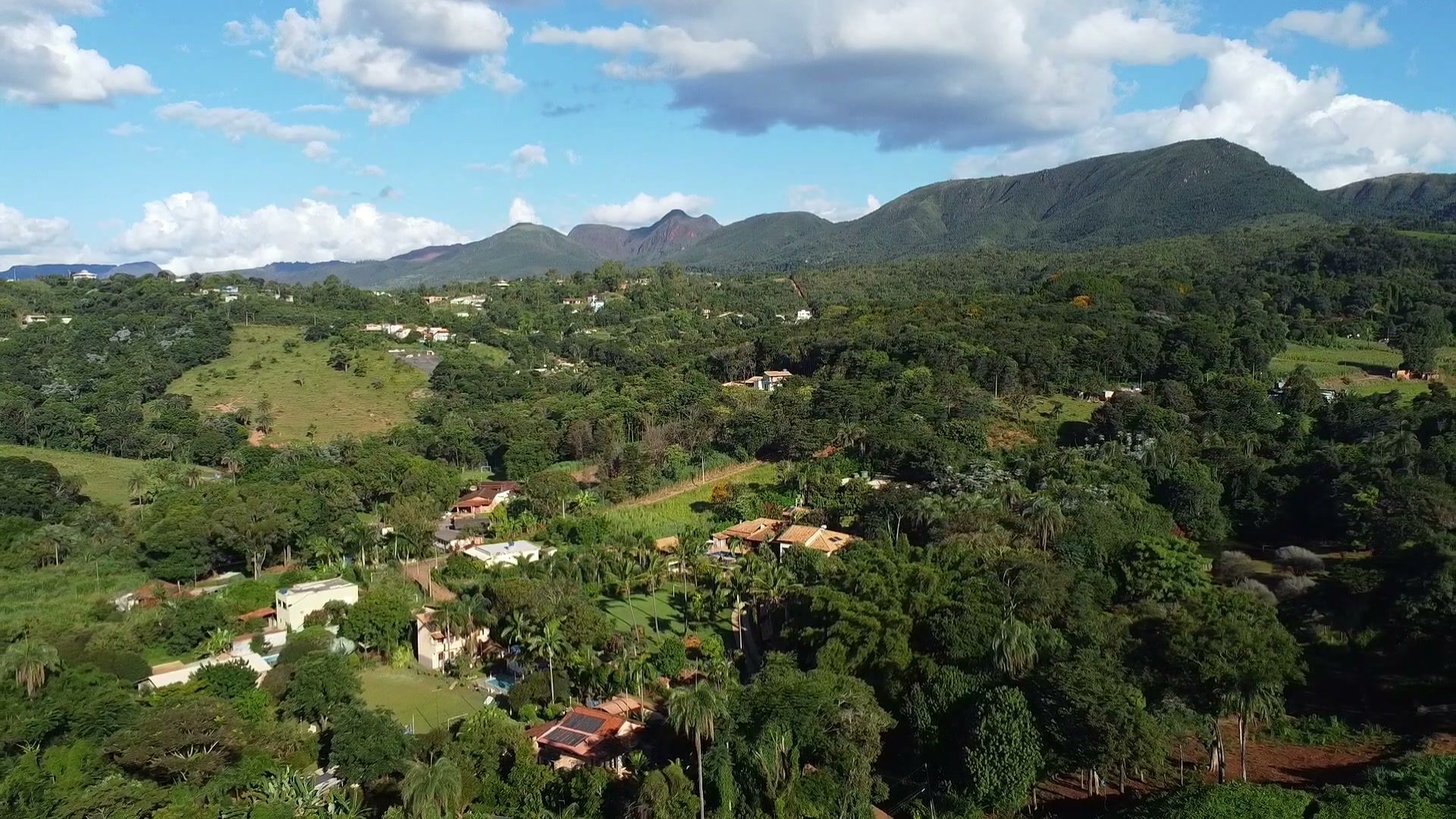Vista do alto de Mário Campos: a serra no horizonte e o vale verde com as casas entre as árvores